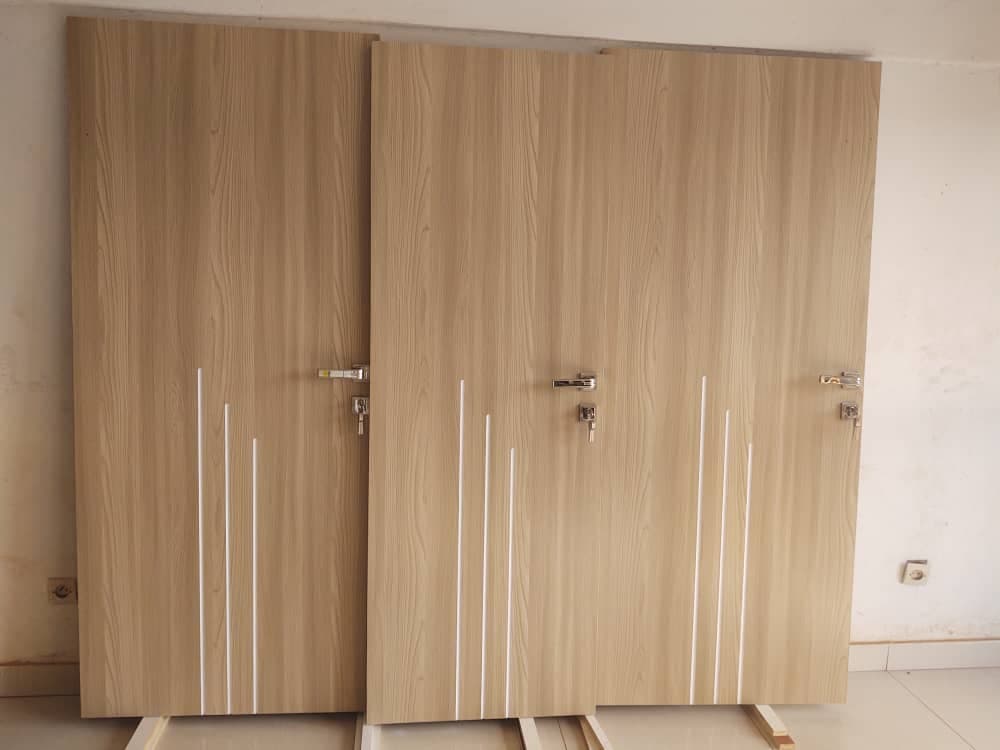 Trois portes en bois clair avec motifs de lignes blanches verticales et poignées argentées.