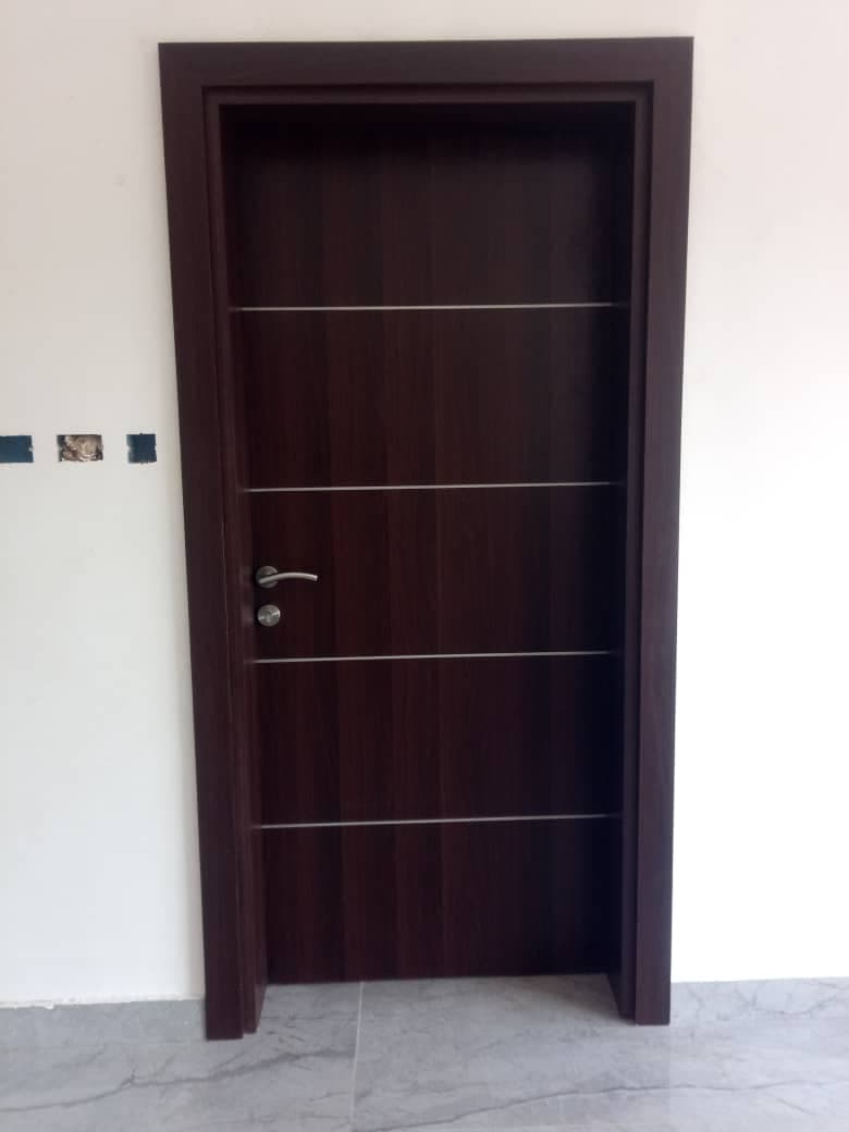 Porte moderne brun foncé avec lignes horizontales argentées et poignée métallique sur fond blanc.