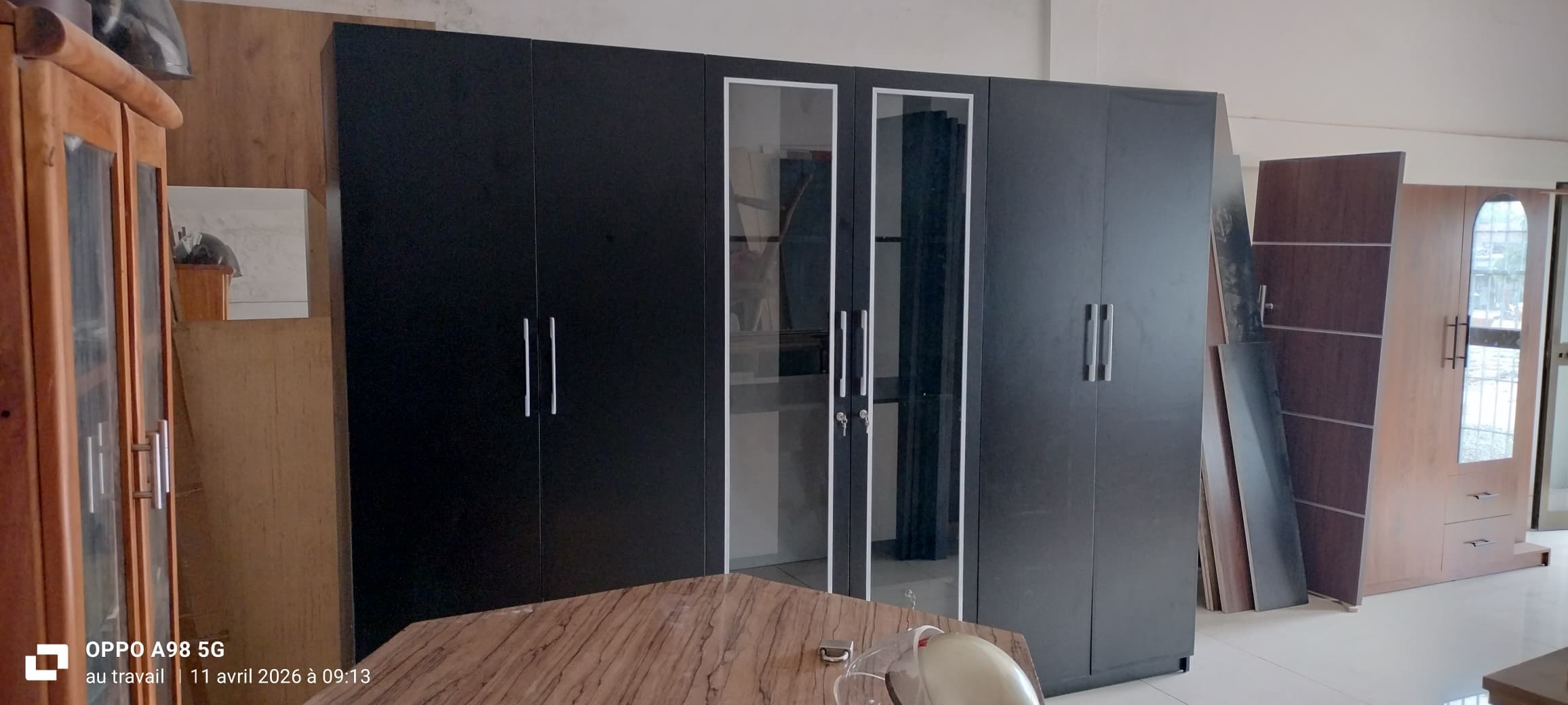 Armoire noire à six portes avec deux vitrines centrales dans un magasin de meubles.
